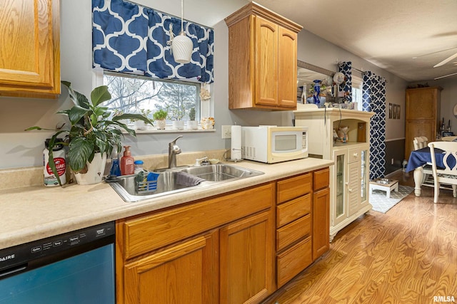 kitchen with light hardwood / wood-style floors, dishwasher, pendant lighting, and sink