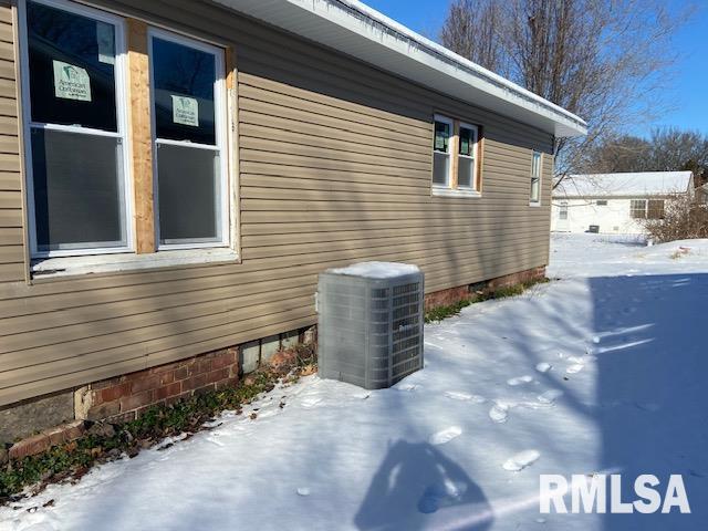 snow covered property featuring central AC