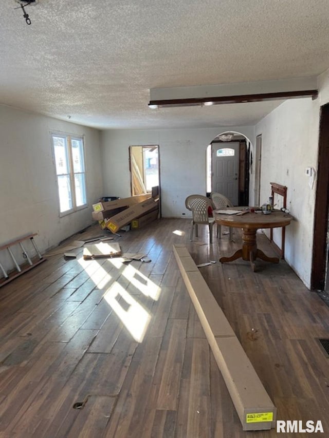 interior space featuring a textured ceiling and dark wood-type flooring