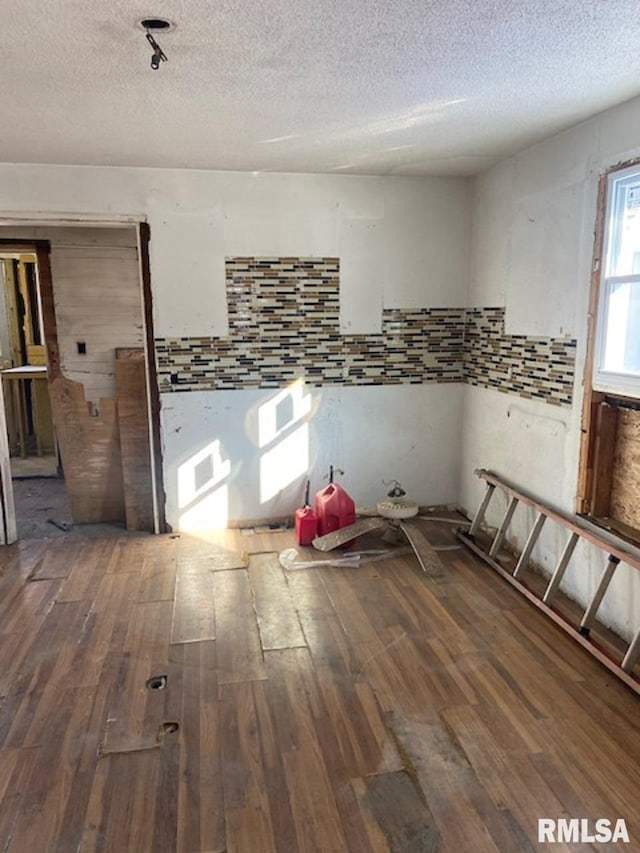 empty room with hardwood / wood-style flooring and a textured ceiling