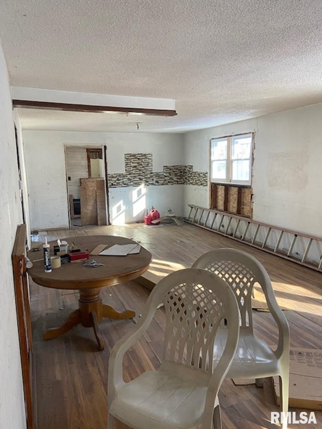 dining space featuring a textured ceiling and hardwood / wood-style flooring