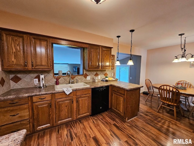 kitchen featuring backsplash, sink, pendant lighting, and black dishwasher