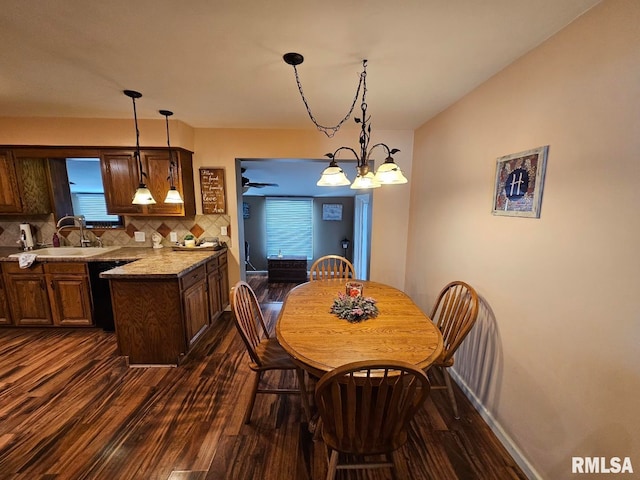 dining room featuring a healthy amount of sunlight, dark hardwood / wood-style flooring, a chandelier, and sink