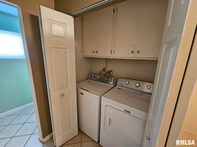 washroom featuring separate washer and dryer, light tile patterned floors, and cabinets