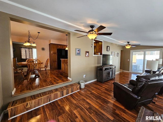 living room featuring dark hardwood / wood-style floors and ceiling fan with notable chandelier