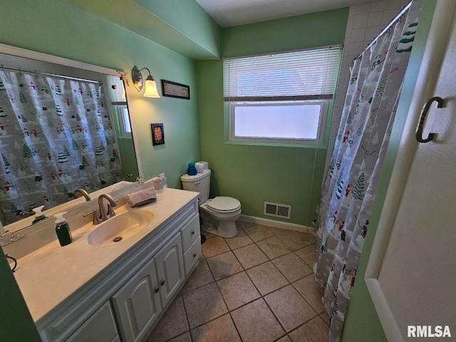 bathroom with tile patterned floors, vanity, toilet, and walk in shower