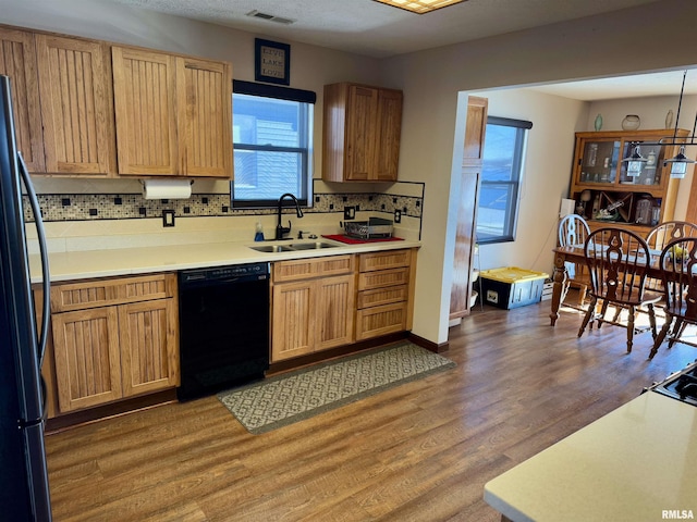 kitchen with decorative backsplash, sink, dark hardwood / wood-style floors, and black appliances