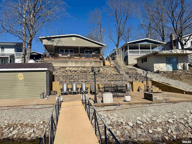 back of property featuring a patio area and stairs