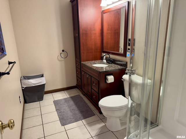 bathroom featuring tile patterned flooring, vanity, an enclosed shower, and toilet