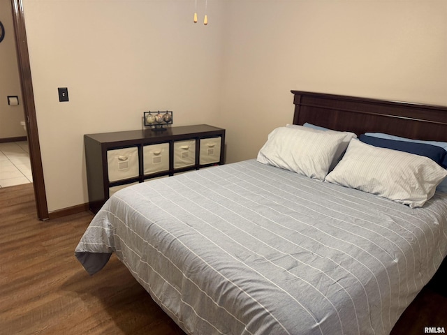 bedroom with dark hardwood / wood-style floors