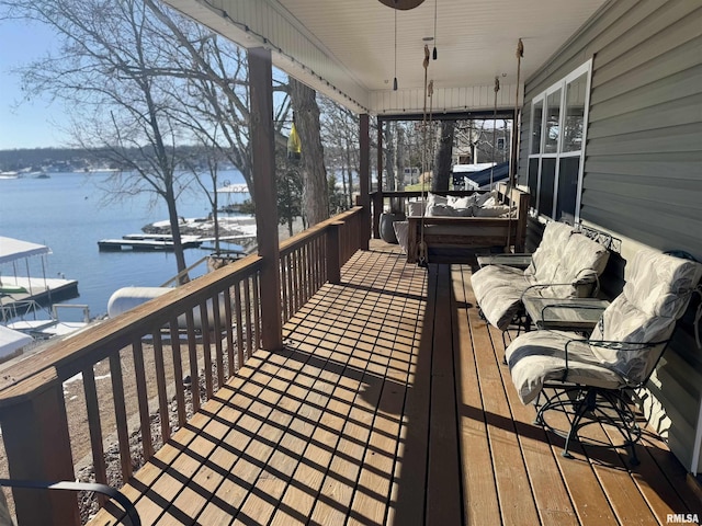 wooden deck with ceiling fan and a water view