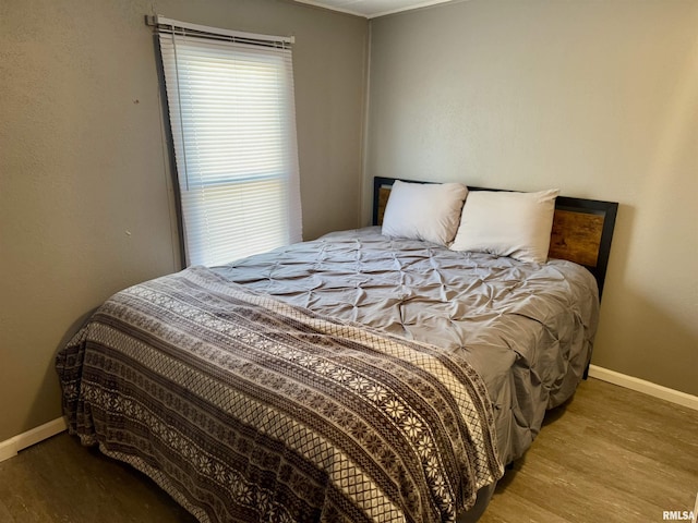 bedroom with baseboards and wood finished floors