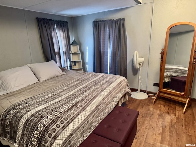 bedroom featuring baseboards and wood finished floors