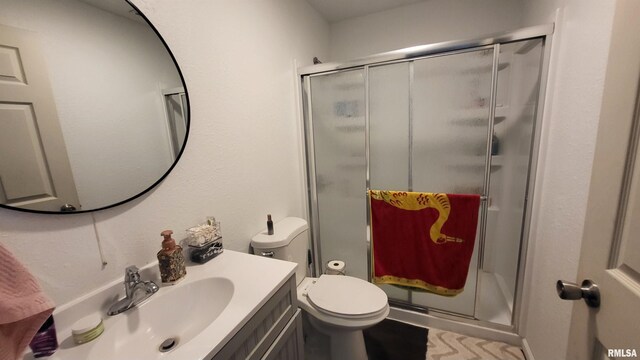 bathroom featuring vanity, toilet, and a shower with door