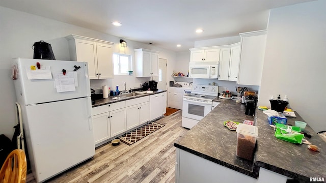 kitchen with kitchen peninsula, white appliances, sink, light hardwood / wood-style floors, and white cabinetry