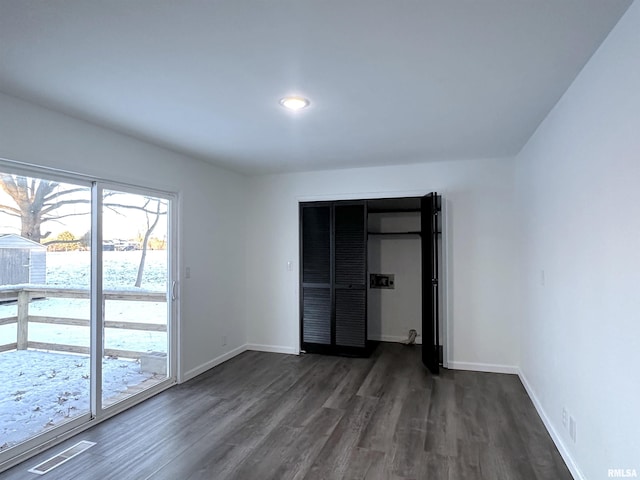 unfurnished bedroom with a closet and dark hardwood / wood-style flooring