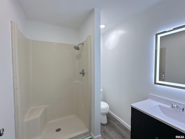 bathroom featuring a shower, vanity, wood-type flooring, and toilet