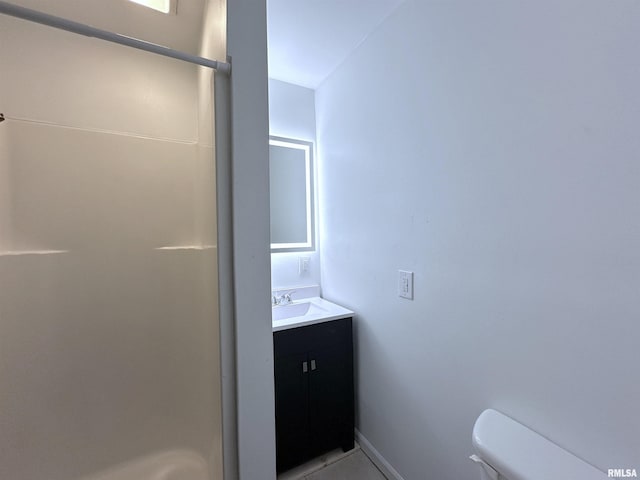 bathroom featuring vanity, toilet, and walk in shower