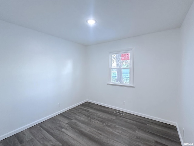 spare room featuring dark wood-type flooring