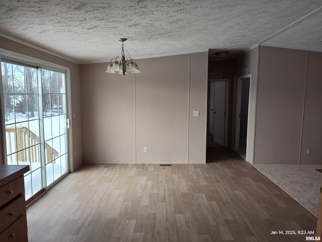 unfurnished dining area with a textured ceiling, light hardwood / wood-style flooring, and a notable chandelier