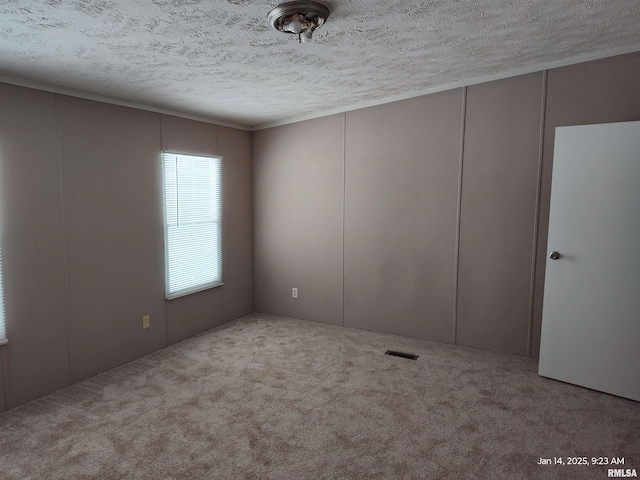 unfurnished room featuring a textured ceiling and light carpet