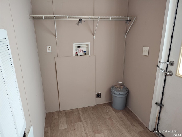 washroom featuring electric dryer hookup, hookup for a washing machine, and light hardwood / wood-style floors