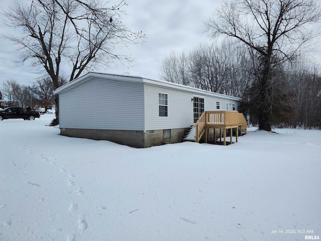 snow covered property featuring a wooden deck