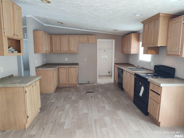 kitchen with light wood-type flooring, vaulted ceiling, sink, black appliances, and light brown cabinets