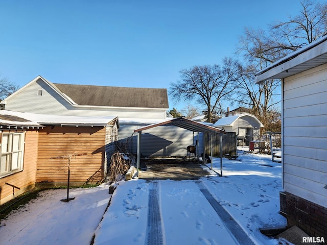 snow covered property featuring a carport