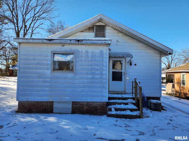 snow covered property with central AC