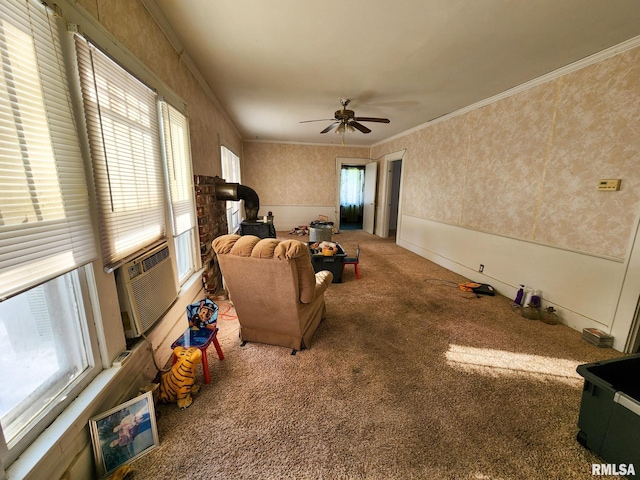 carpeted living room featuring a wood stove, a wealth of natural light, ornamental molding, and ceiling fan