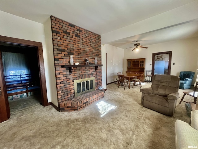 carpeted living room featuring a brick fireplace and ceiling fan