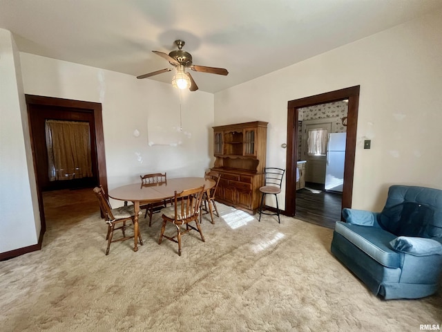 dining room featuring ceiling fan and light carpet