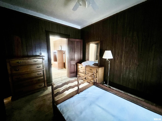 bedroom with ceiling fan and wooden walls