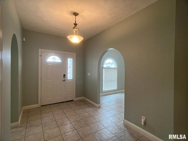 tiled entryway with a textured ceiling