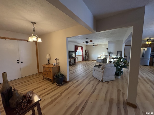 living room featuring a textured ceiling, hardwood / wood-style floors, and a chandelier