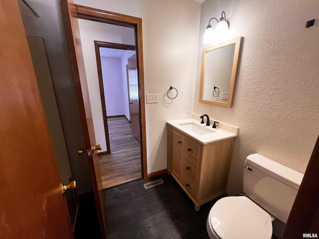 bathroom featuring toilet and vanity