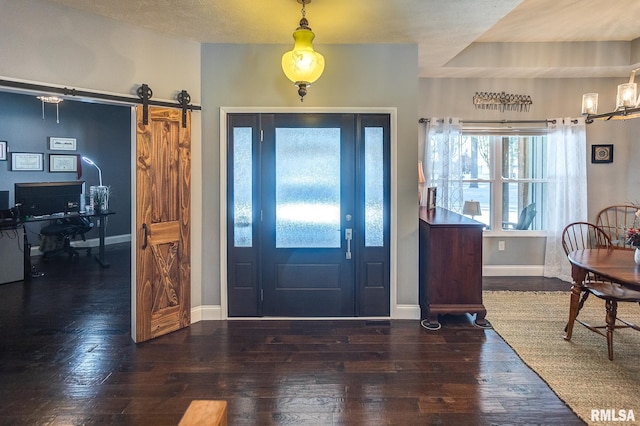 foyer with a barn door and dark hardwood / wood-style flooring