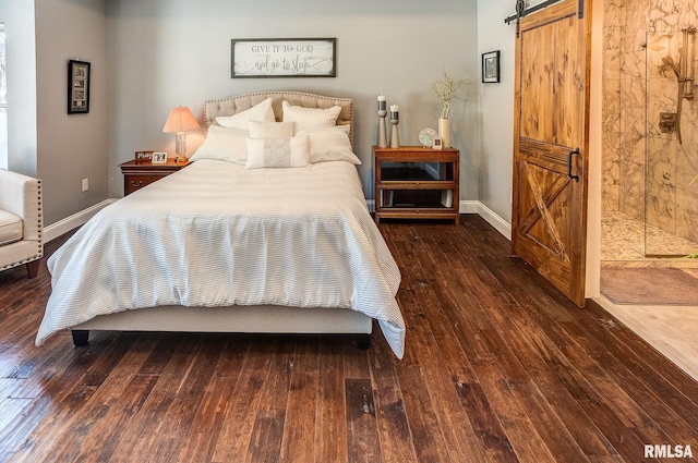 bedroom with dark hardwood / wood-style flooring and a barn door