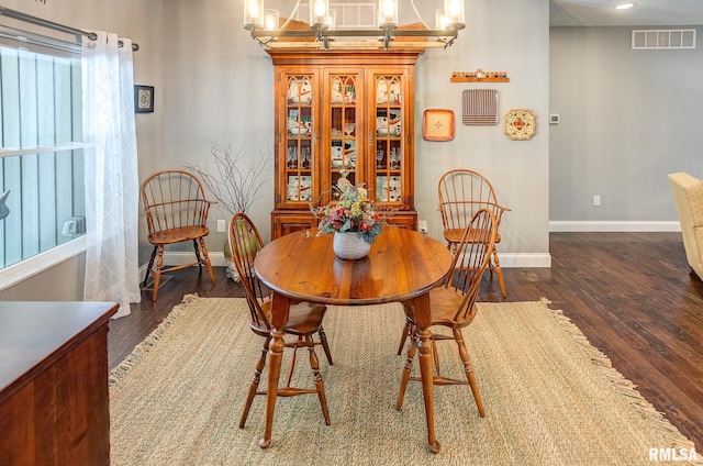 dining room featuring an inviting chandelier and dark hardwood / wood-style floors