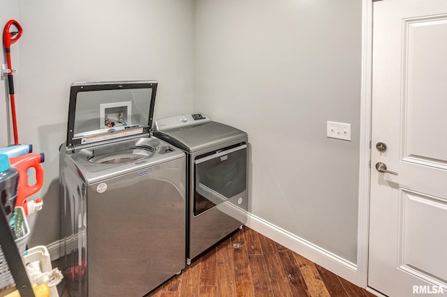 clothes washing area featuring washer and dryer and dark wood-type flooring