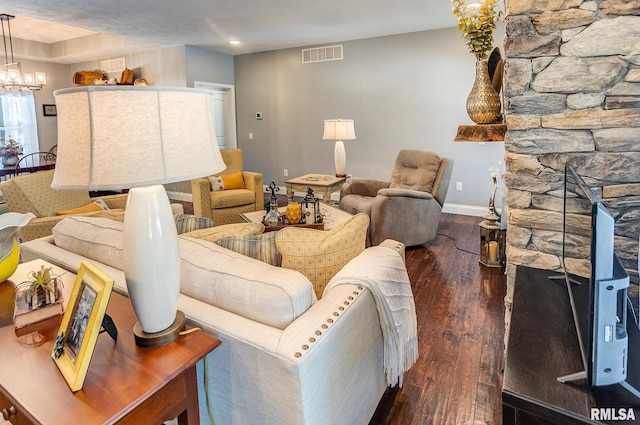 living room with dark wood-type flooring and an inviting chandelier