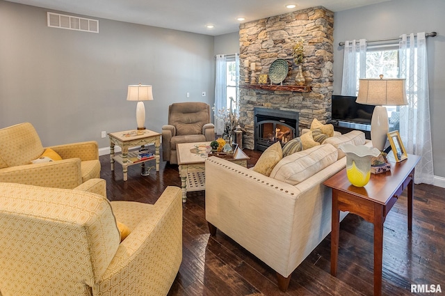 living room with dark wood-type flooring and a fireplace