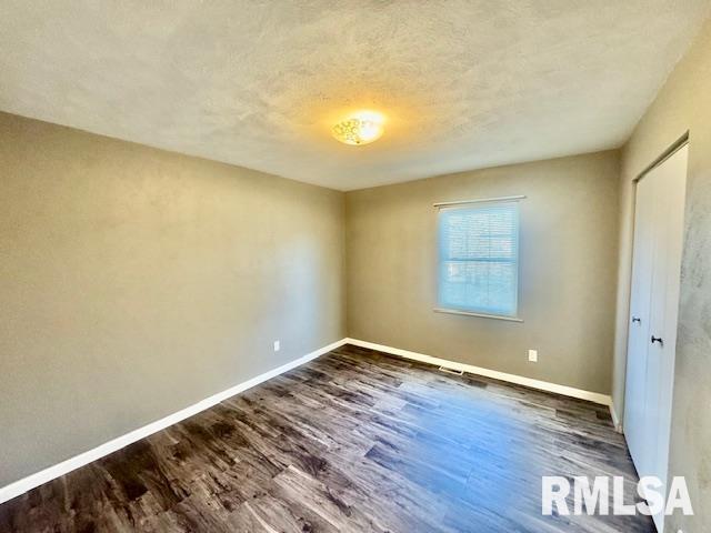 unfurnished bedroom with dark hardwood / wood-style floors