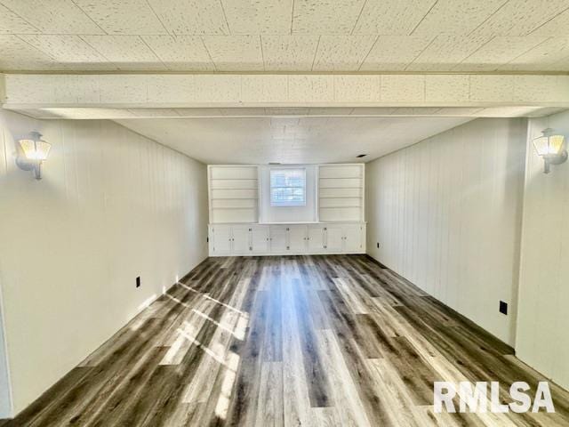 interior space featuring dark hardwood / wood-style floors and wood walls