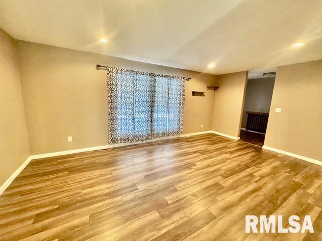 spare room featuring radiator and hardwood / wood-style floors