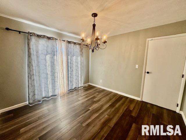 unfurnished dining area featuring dark hardwood / wood-style flooring and a chandelier