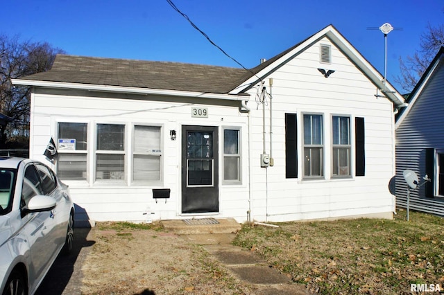 bungalow-style home with a front yard