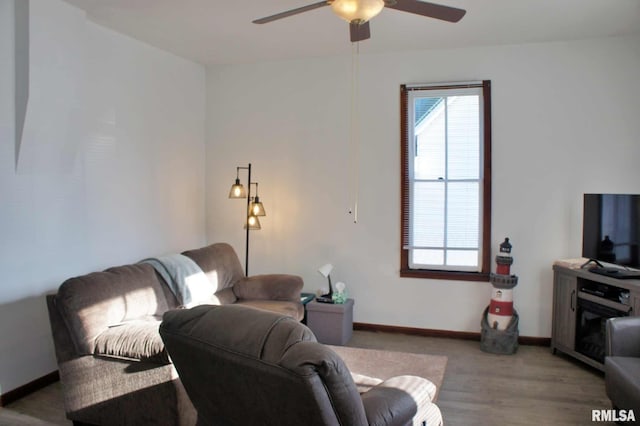 living room with ceiling fan and light hardwood / wood-style flooring