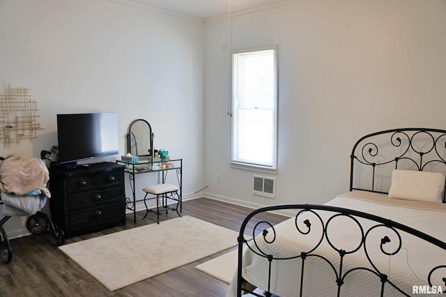 bedroom with dark hardwood / wood-style flooring and ornamental molding